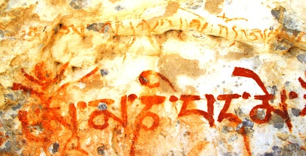 Fig. 8: The first five syllables of the six-syllable mantra of the Bodhisattva of compassion, Che letters were boldly written in deep red ochre. The initial syllable Om with its superscribed tripartite vowel and consonant sign represents an obsolete calligraphic flourish. This paleographic trait suggests that the mantra was written prior to 1300 CE. As for a terminus a quo, a date before 1000 CE is not likely, because there is little archaeological evidence for a strong Buddhist presence in the Changthang prior to that time. Even more interesting is the upper inscription scribbled in orange-red ochre. This mantra belonged to a non-Buddhist cult (or perhaps more aptly, a pre-Buddhist cult) of Upper Tibet, which can be labeled ‘Bon’ in the most inclusive sense of the word. It reads: “A A A dkar sal le ’od A (followed by two or three largely illegible syllables that should read: yang Om’ ’du)”. This is the first part of the well-known mantra of Kuntu Sangpo (Kun-tu bzang-po), the primordial Buddha of the Great Perfection (Dzokchen, rDzogs-chen) tradition, a profound system of mind training and metaphysical speculation. This sacred ejaculation is supposed to have been first recited by Tonpa Shenrab, the legendary founder of the Eternal Bon religion. It is also worth pointing out that the letter A in Dzokchen represents the primal ground of consciousness. The terminus ad quem of this inscription is circa 1250 CE but it could actually be considerably earlier. In Tibetan literature, Bon and Buddhist Dzokchen are traced to the early historic period (Bonpos hold that it was even practiced in prehistoric times, but this cannot be conclusively established). Despite Kuntu Sangpo also being a deity of Tibetan Buddhism, this non-Buddhist mantra appears to have been deliberately smudged, as probably were other pigment applications underneath and adjacent to Chenresik’s mantraenresik (sPyan-ras-gzigs), are visible in this image. 