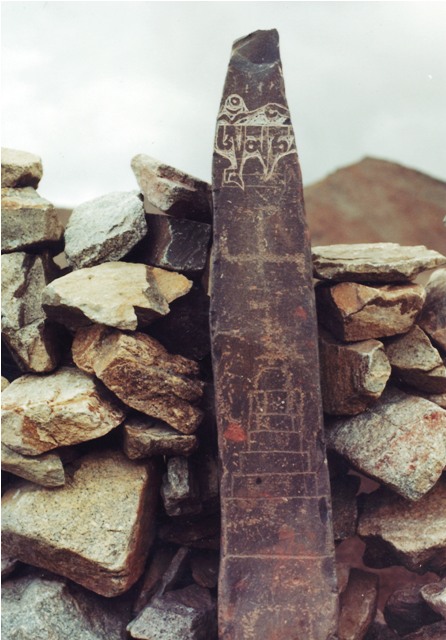 Fig. 14. One of a number of pillars in northwestern Tibet integrated into a corral. Presumably there was once an enclosure as well. This particular specimen was engraved with a swastika and two primitive shrines at different times long ago. In contrast, the letters Om’ ma ni at the top of the stele were carved at a much later date, as indicated by the relative level of erosion exhibited by the various carvings