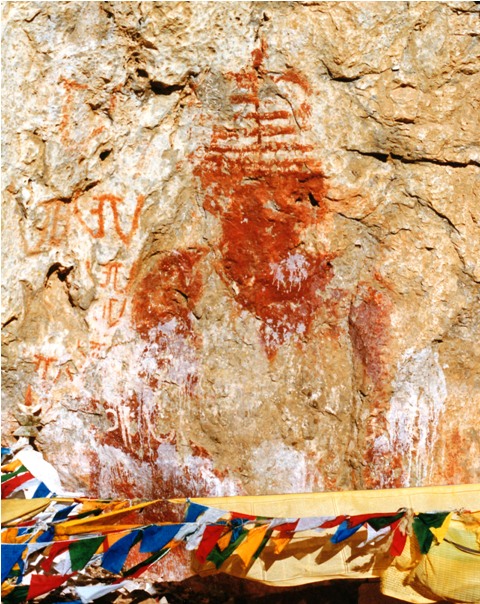 Fig. 17. Much of this giant red ochre chorten has disappeared over time. It appears that it was also literally whitewashed in order to remove its presence. The squat pyramidal spire and broad midsection and base are design traits of archaic shrines. This is corroborated by the inscription to the left of the chorten in which the Tibetan letter A has been written vertically several times. These large letters were inscribed in the same ochre hue and exhibit similar wear characteristics as the chorten, suggesting that they date from the same timeframe. The style of calligraphy is archaic and could well date to the early historic period. The chorten may possibly be ascribed to the early historic period but, in any case, it was painted before circa 1250 CE and the definitive Buddhist conquest of the region. This shrine and inscription were almost certainly made by those belonging to a non-Buddhist or bon cult