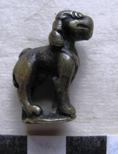 Fig. 19. At little more than 3 cm in height, this copper alloy figurine of a standing lion was made to wear. This beautifully modeled thokcha (thog-lcags) probably functioned as a talisman or insignia. It probably dates to the imperial period and is of Tibetan manufacture as well. Its mane and head bear considerable resemblance to the Chonggye stone lion. Shang Nyima collection
