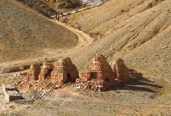 Fig. 8. The recently ransacked chorten complex of Khyunglung Yulme. These chortens are situated near a large village but despite their conspicuous location they were not safe from the well supported activities of thieves. This site and the caves above are now being developed for mass tourism with the construction of a road right up to its base. The lovely white pools of a nearby sacred hot spring have been run over by a bulldozer for no apparent reason. 