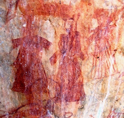 Fig. 1. A trio of human figures attired in ankle length robes or caftans gathered at the waist and with relatively short sleeves. These figures and two nearby ones are unlike the depiction of any other anthropomorphic rock art in Upper Tibet. The red ochre figures have undergone considerable wear and ablation of the pigment (each figure is in the vicinity of 10 cm in height). Moreover, the composition is partially obscured by subsequent pigment applications and the running of pigment from adjacent pictographs. As for the age, I shall tentatively attribute it to the imperial period (circa 630–850 CE). Note the line drawing of a yak (horns visible on bottom left corner) superimposed on the composition at a later date.