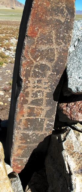 Fig. 11. This chorten carving with its long and narrow form, small round bumpa and horn-like finial can also be ascribed to the early historic period. This periodization is supported by the carving technique used as well. A small archaic chorten of three tiers with a rounded upper section was also carved near the top of the pillar. I failed to document these two rock art chortens during my 1999 survey of the site. Unlike other petroglyphs at this location, these examples were placed on the west side of a pillar.