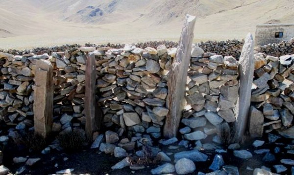 Fig. 5. Like the other four specimens at the site, these four pillars or stelae were hewn from igneous rocks. The two pillars on the right side of the photo are made from white granite and are 1.4 m and 1.6 m in height (not including the portions firmly anchored in the ground). I am not certain how far away the quarry for these pillars was located – that’s something for further research. The third pillar from the right was engraved with several mani mantras and traces of other short inscriptions and designs that are now almost effaced.