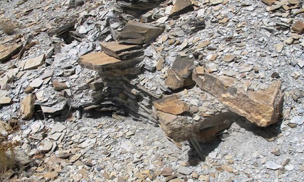 Fig. 8. A structure almost entirely engulfed by rubble in Sector III. Two large corbels are still in situ, signaling that this was an all-stone corbelled edifice. Also note the curvature in the rear wall of the structure, another trait of this type of architecture. The rear wall was set deeply into the steep slope, which must have given the building a semi-subterranean aspect. It is common in Upper Tibet to find this kind of structure built partially underground. 