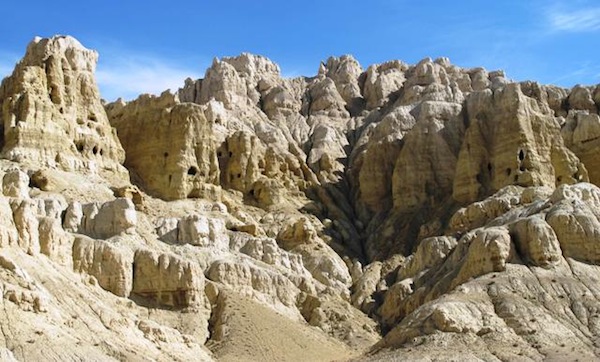 Fig. 2. The cave complexes sandwiched between the fields and castle. These are artificially created grottoes typical of Guge. A series of wooden gangways and ladders may have been used to access the caves from above. 