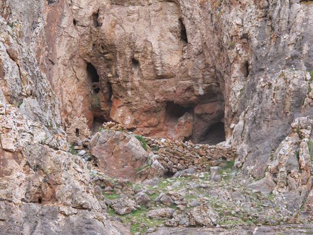 Fig. 2. The mouth of the cavern in which forward retaining wall and one of the chortens of the sanctuary can be seen. On the rear wall of the cavern, in the middle of the photograph, two mainly white pictographs of chortens are discernible. 