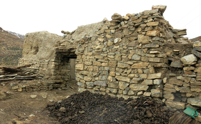 Fig. 11. The east side of the old house of the jowa, Tashigang. The massive east wall is about 1 m thick. Note the composite stone and wooden lintel over the entranceway and the coursed-rubble stonework.