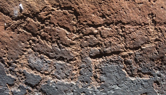 Fig. 44. A shrine with a triangular form divided into of four tiers (12 cm high) and counterclockwise swastika carved on top of a boulder, Lari Tingjuk. On top of the same boulder are geometric designs. Protohistoric period.