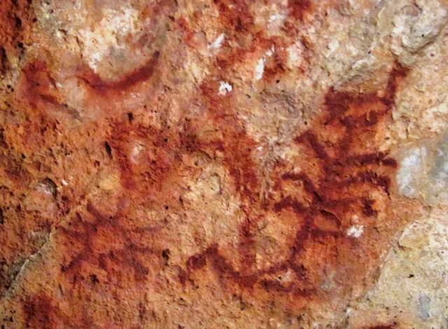 Fig. 82. A portion of a panel of red ochre pictographs at Lhari Drakphuk, Upper Tibet. Clearly visible in a deep red ochre hue is a sunburst, crescent moon and tree. Protohistoric period.