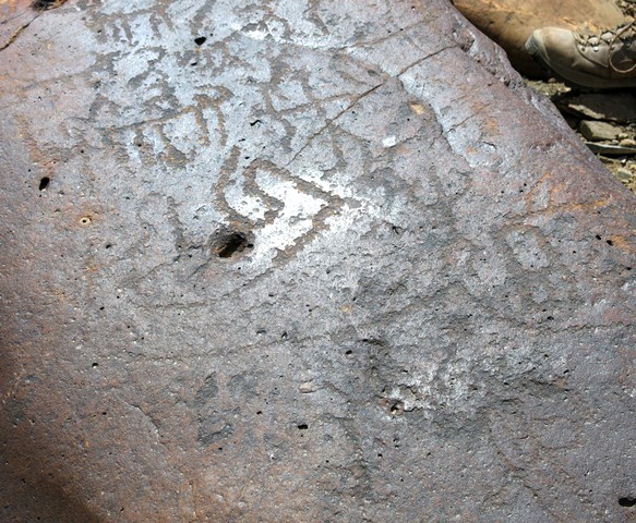 Fig. 11.33. On this boulder can be seen a bowman (upper middle of photo) surrounded by his prey, wild caprids. In the center of the boulder is a linear motif that is almost letter-like. Animals and other figures occupy the lower part of the rock. Protohistoric period.