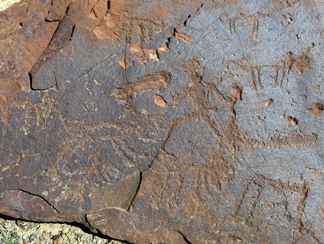 Fig. 14.30. Anthropomorph (11 cm high) surrounded by wild caprids. The anthropomorph and other less re-patinated figures appear to date to the Early Historic period. More highly worn and re-patinated figures at bottom left are attributable to the Protohistoric period.