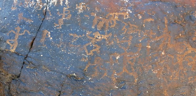 Fig. 18.31. Five or six anthropomorphic figures and swastika (middle of top) on the left side of the boulder in fig. 18.29. These anthropomorphs are depicted engaged in an energetic activity. Note that two of the human figures don pyramidal headgear. The Early Historic period Tibet inscription reads rta-zog-pa (horse requisitions).