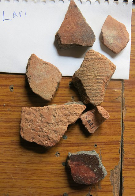 Fig. 8. Smooth-walled and cord-marked redware from the village of Lari. Note what appears to be part of a handle marked “Lari”. Some of these ceramics may have been deposited in tombs.