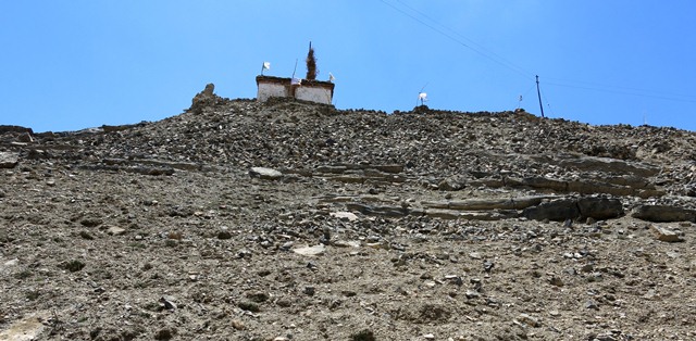 Fig. 12. The northeast side of the hill at Kharteng. Note the lhatho shrine and chapel on the summit and the rubble strewn slopes below.