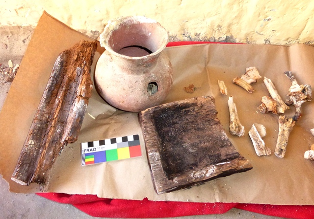 Fig. 19. Close-up of globular pot and wooden objects in fig. 17. The thin-walled globular jar with flared neck appears to have been fitted with two handles, one of which has broken off. Both pieces of wood have been worked. Photo courtesy of SRAHS.