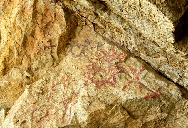 Fig. 28.10. Pictographs on west wall of Sinmo Khadang situated above rock face in fig. 28.3. There is a large sunburst in the middle of the image. Above it is a pair of anthropomorphs flanked by swastikas forming a single composition.