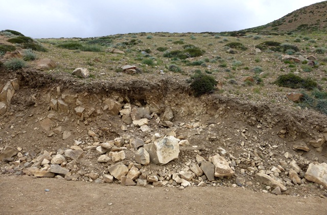 Fig. 36. A tomb (rocky area in middle of photograph) at Tashigang sliced open by road construction. Photo courtesy of SRAHS.