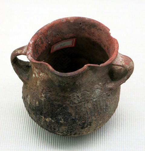 Fig. 68. Wide-mouthed globular jar with brownish exterior, short neck, two strap handles, rounded spout, and cord-marked treatment. This vessel was discovered in the “Kaerbu” (Tibetan = Mkhar-bu?) cemetery, Guge, Western Tibet. Probably Iron Age. Tibet Museum collection.