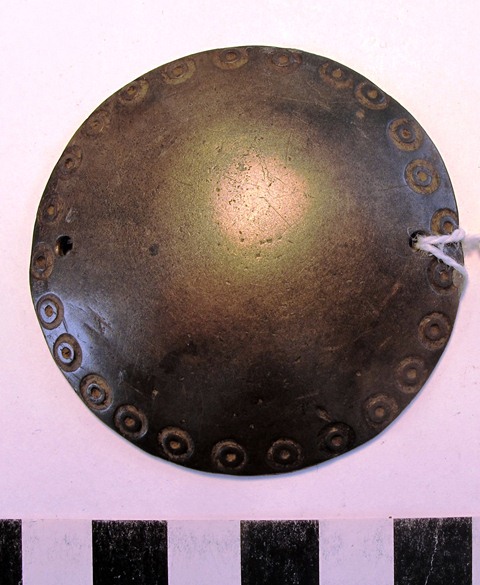 Fig. 19. Hemispherical mirror with a band of embossed ‘eyes’ (mig). Note the perforation in the object made so that it could be suspended. Such mirrors were worn on the headgear and over the mantles of Tibet sprit-mediums. Moke Mokotoff collection, New York.