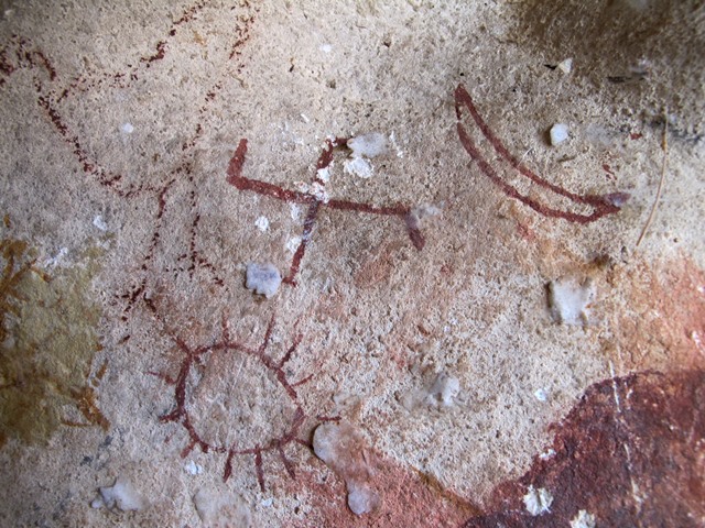 Fig. 1. The swastika accompanied by a sun probably of 13 rays and the crescent moon painted in red ochre (oxides of iron). Eastern Changthang. Iron Age. The light-colored lumps in the image are dabs of butter added by pilgrims.