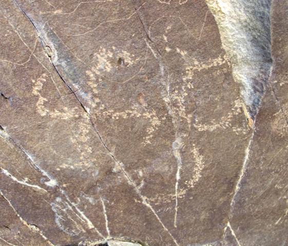 Fig. 7. Swastika, sun and crescent moon lightly etched on a rock surface, northwestern Tibet. This triad of cosmic figures is the same as others depicted above, except that the swastika is oriented clockwise. Protohistoric period.
