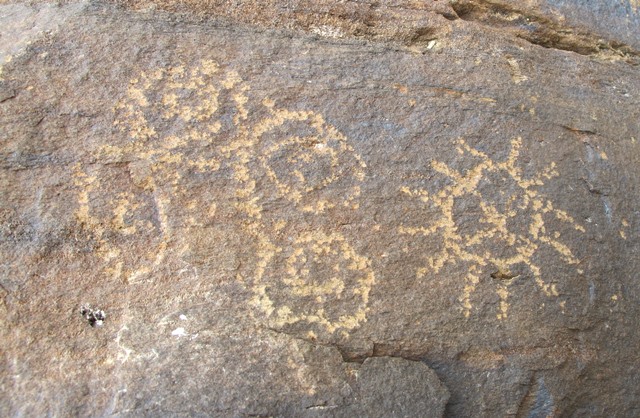 Fig. 9. A sun with 12 rays and a cross with bent legs in the disc, northwestern Tibet. Next to it are four interconnected circles, each of which contains smaller circles. Like the sunburst, these curvilinear subjects may have had cosmological symbolism. All of these carvings appear to form an integral composition. Protohistoric period.