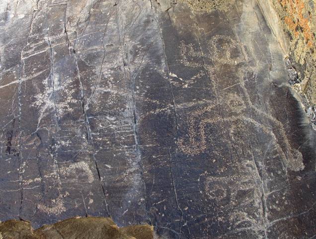 Fig. 10. A possible birth-giving scene, northwestern Tibet. The sun and swastika signs were carved opposite an anthropomorphic figure with upraised arms and spread legs. Above the legs of this figure is a circle that may represent the womb. The petroglyph below the anthropomorph has not been identified.