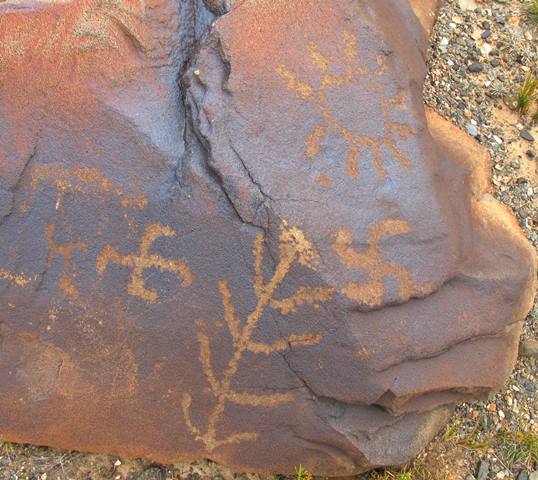 Fig. 11. Two swastikas, tree and sun, western Changthang. The swastika on the left has legs oriented in the same direction on each axis, interrupting the radial symmetry of this geometric form. Swastikas with legs out of sync are commonplace in the early rock art of Upper Tibet. These kinds of eccentric swastikas are still seen occasionally in contemporary Tibetan folk art. Probably Iron Age.