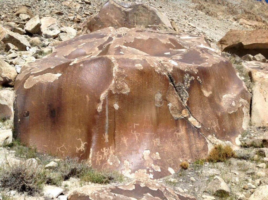 Fig. 21. A single boulder with anthropomorphs in a dancing/celebratory scene, accompanied by animals and horsemen, lower site, Saser La. A faint chorten outline is visible in the centre of the boulder.