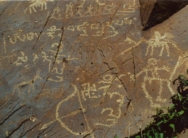 Fig. 60. Buddhist rock art and inscriptions, central Changthang. Vestigial period. The upper inscription is the vajra mantra for Guru Rinpoche. Higher up on the rock face is another Buddhist composition which I have treated elsewhere. Although the swastika accompanying the syllable hum’ and bow and arrow faces counterclockwise, it is a Buddhist symbol. The detailed but clumsily executed horseman and standing anthropomorphic figure typify the decadence of Upper Tibetan rock art in the final period of production.