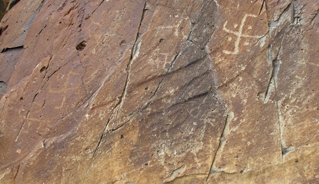 Fig. 66. Older and more recent swastikas embellishing a cliff at a site in the eastern Changthang, which appears to have witnessed vigorous interactions between Tibet’s contending religious traditions in the Early Historic period and Vestigial period. A deer and other figures are also seen on the same cliff.