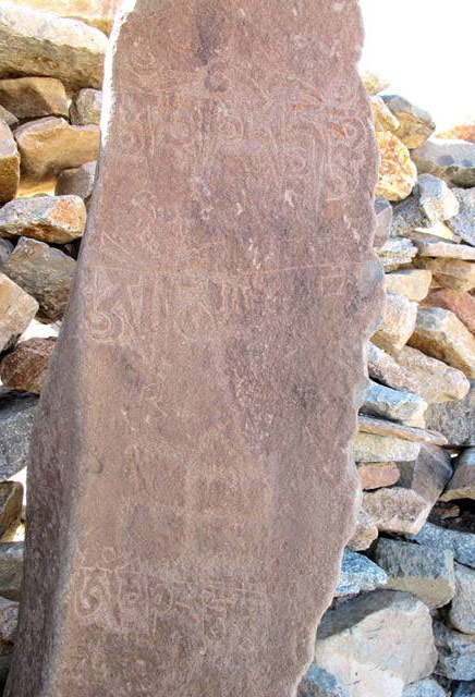 Fig. 79. Counterclockwise swastika and more recent mani mantras added to a prehistoric funerary ritual pillar, northwestern Tibet.