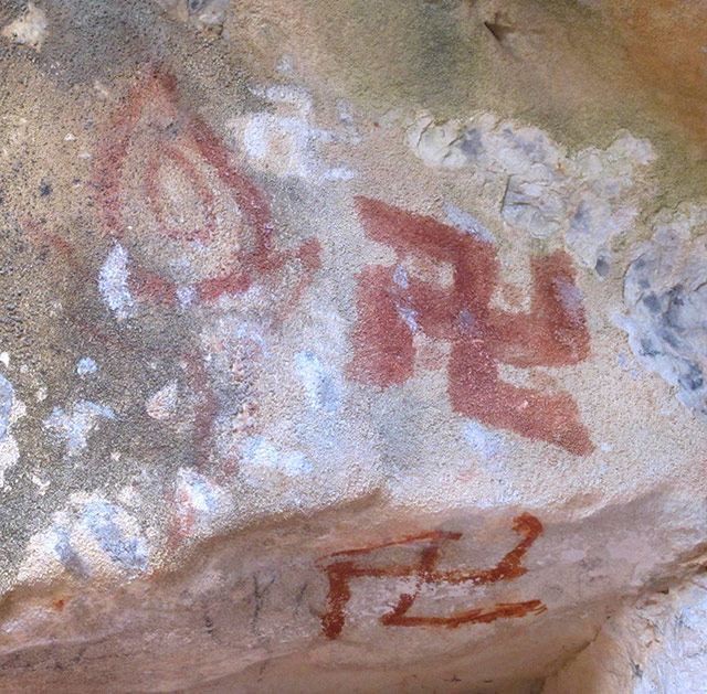 Fig. 81. Three different red ochre counterclockwise swastikas and conjoined sun and moon in rear of large, round cave, eastern Changthang. This early style conjoined sun and moon is also seen in copper alloy talismans (thog lcags). As with stepped shrines and flaming jewels, it was once favored by both Buddhists and non-Buddhists.