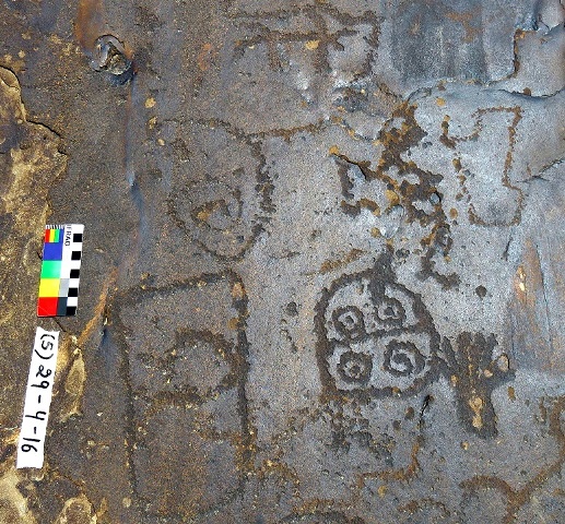 Fig. 2. Two of the mascoids and handprint in fig. 1 (lower half of image). Above the mascoids is a spiral and other carvings. Photograph courtesy of the Spiti Rock Art and Historical Society.