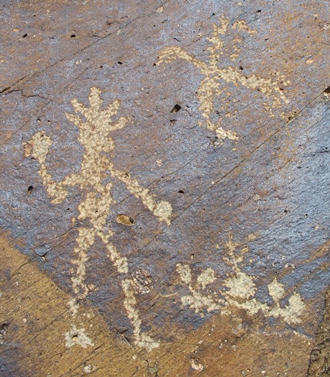 Fig. 25: Anthropomorphic figure standing before a row of circular objects with a swastika-like bird overhead. Protohistoric period.