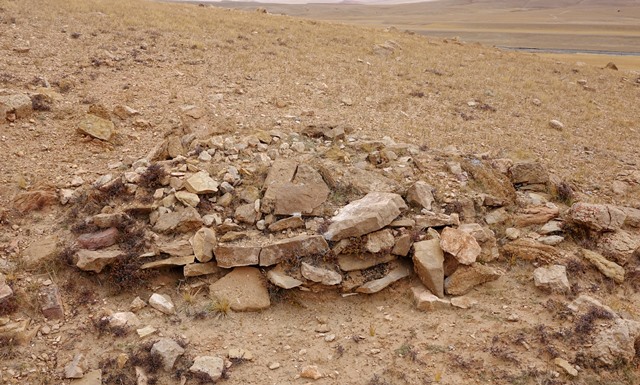 Fig. 27. A tomb comprised of several vertical courses of masonry (FS5). Perched on the edge of a gully, this tomb was exposed some years earlier by running water. Human bones are no longer visible on the surface of the structure.