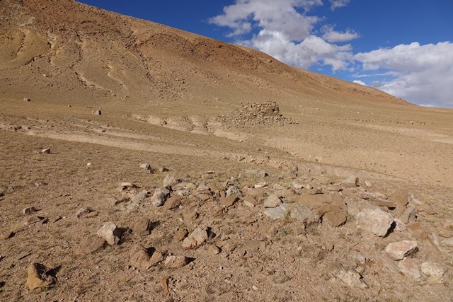 Fig. 31. Vestiges of funerary structure FS11 with the Central Complex of TBRH in the background below the ridge.