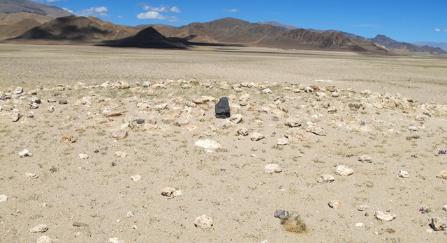 Fig. 17. All that remains of the temple-tomb is a rocky tumulus and scant traces of the east wall of the old masonry edifice. The dark stone in the middle of the mound appears to be one of the uprooted pillars.