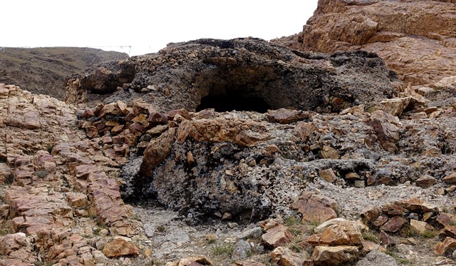 Fig. 14. Small cave in a mass of conglomerate and the remains of a wall on the south side of the defile at Gondak.