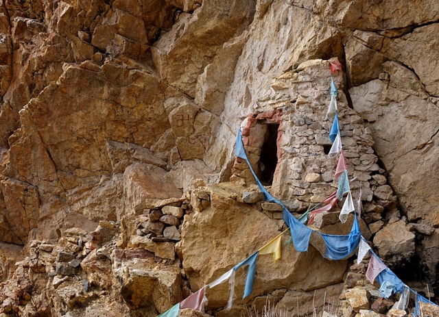 Fig. 30. Cave with ritual functions in formation with pyramidal façade tinted white and red. Note the remains of stone steps leading up to this structure. To the left of the cave a Tibetan letter A and a counterclockwise swastika painted in red ochre are visible.