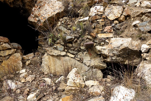 Fig. 36. Rear wall of west room in middle tier. Note the reddish corbel (also seen in fig. 35) and chamber under the rear wall (right side). The entrance to the adjoining cave is on the left side of the photograph.