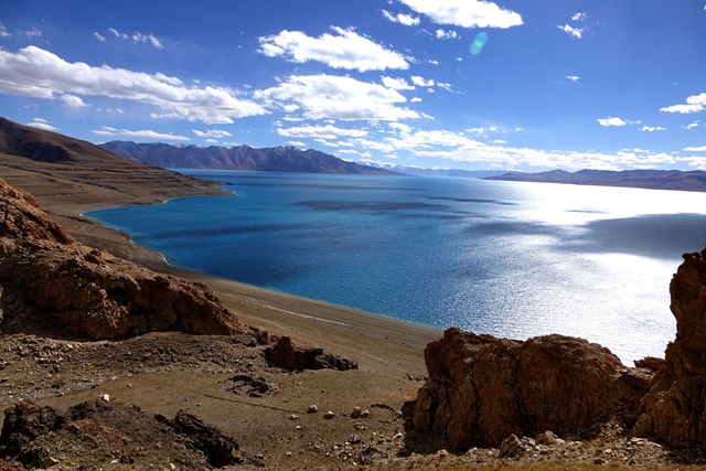 Fig. 48. The view of magnificent Lake Dangra from the twin shrines. In the far distance are the snowy peaks of the Targo (Rta-sgo) range. The shelf with the large shrine complex is visible below the upper slopes. On the lower right side of the photograph is the notch in the formation accessing the lakeside shelf.